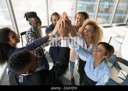 Friendly young african colleagues joining hands in air. Stock Photo