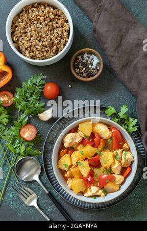 The concept of Diet menu. Homemade turkey or chicken with pineapple sauce and boiled spelled on a dark stone table. Top view flat lay background. Stock Photo