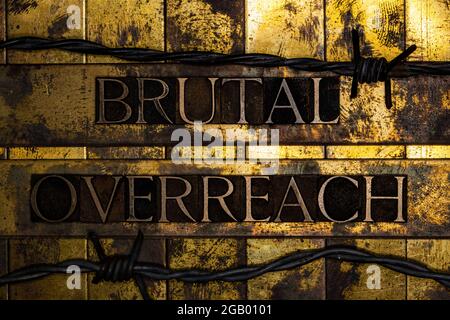 Brutal Overreach text message on grunge textured gold and copper background Stock Photo
