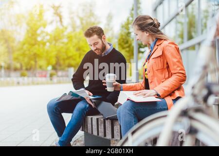 Man and woman student chatting on university campus Stock Photo