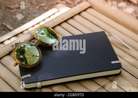 Glasses and notebook on the natural wooden bamboo table background for the concept of finance life future design planing style Stock Photo