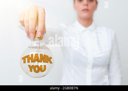 Conceptual caption Thank You. Business showcase a polite expression used when acknowledging a gift or service Lady in outfit holding lamp upside down Stock Photo