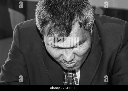 An Asian male businessman is sad and crazy upset for his failure management in finance business investigation work and job during a strong economic cr Stock Photo