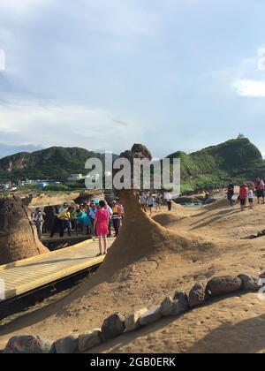 New Taipei, Taiwan - July 6, 2015: View of people attraction to Queen's head stone at Yehliu Geopark Park in the northern coast of Taiwan. Stock Photo