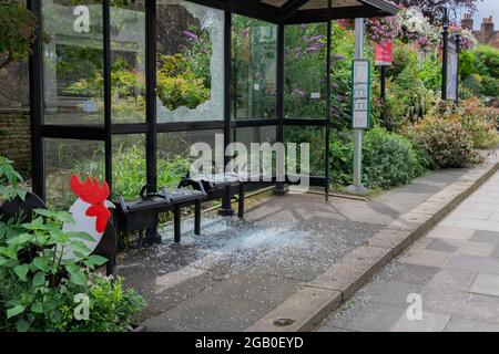 Dorking, Surrey, UK, 08-01-21: A Newly Replaced South Street Bus Shelter Window Smashed with a Spray of Glass on the Public Seats and Waiting Area. Stock Photo