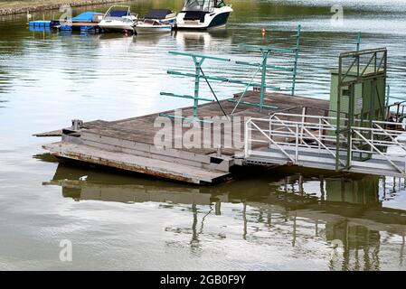 A metal platform protruding from the river bank on air tanks, a pier to the entrance to the ship. Stock Photo