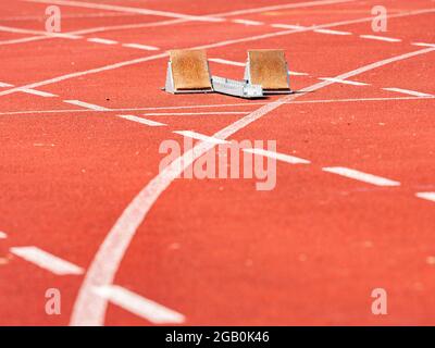 Empty Starting Blocks and red running tracks in a stadion. Athletic training Stock Photo