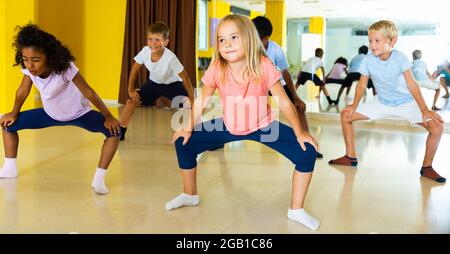 Portrait of smiling children practicing sport dance in modern dance hall Stock Photo