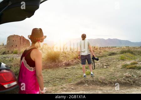 rear view of young asian couple car travelers enjoying the morning sunlight on the road Stock Photo