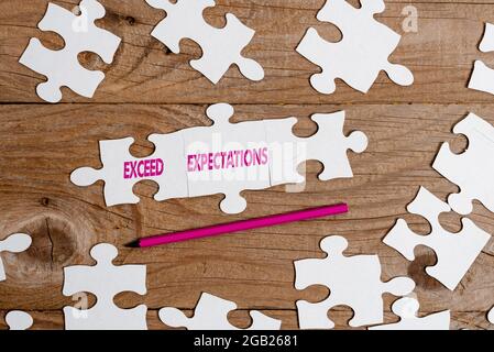 Text caption presenting Exceed Expectations. Business concept able to surpass or beyond the acceptable performance Building An Unfinished White Jigsaw Stock Photo