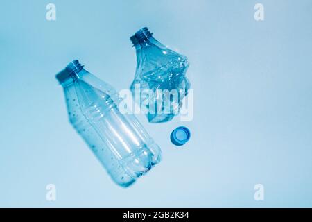 Used empty crumpled plastic bottles on blue background. Recycling recycled plastic. Pollution, environmental protection. Stock Photo
