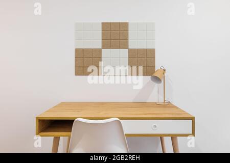 Front view of stylish room interior with modern comfortable workplace. Wooden table with white wall and chair. Stock Photo