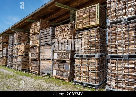 Firewood in stacked old lattice boxes Stock Photo