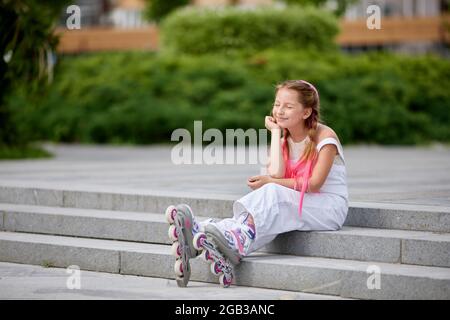 cute little girl on roller skates at park. Stock Photo