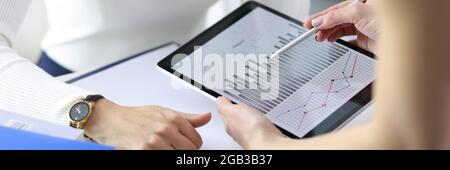 Businesswoman showing colleague graph on digital tablet closeup Stock Photo