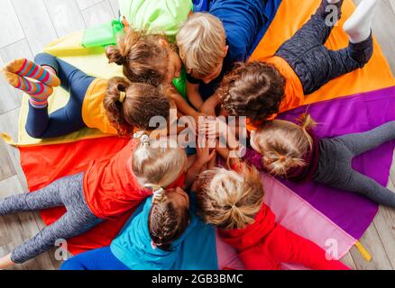 Cheerful children playing team building games on a floor Stock Photo