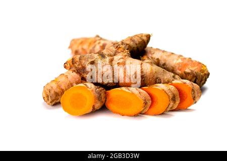 Fresh turmeric roots and slices on white Stock Photo