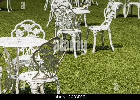 white nice tables and chairs on a green meadow at a wedding in the summer with sun Stock Photo