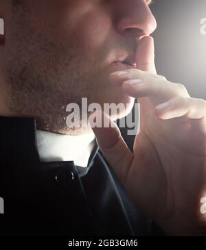 secret of a young priest in a black cassock Stock Photo