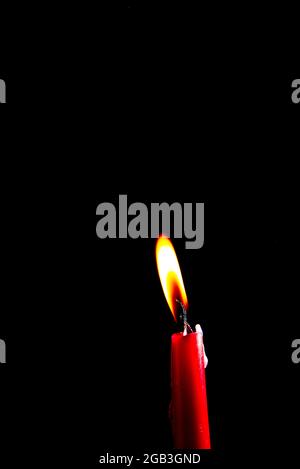 single burning candle against black background Stock Photo