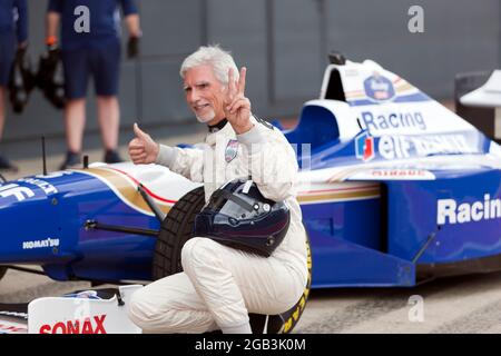 Damon Hill posing beside his World Championship Winning Williams FW18  Formula One Car, after performing several high speed demonstration laps of the circuit, at the 2021 Silverstone Classic Stock Photo
