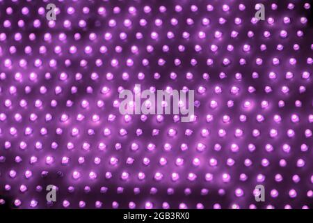 cheap outdoor purple led screen panel with individual diodes, full frame close-up view with selective focus. Stock Photo
