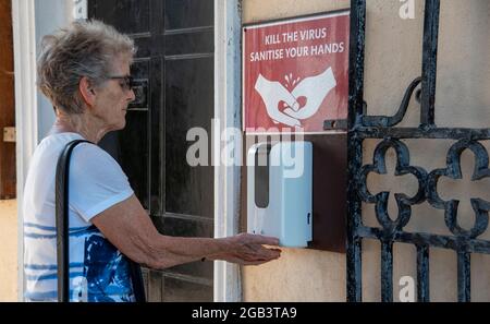 Cornwall, England, UK. 2021. Woman at a hand sanitising point for the general public to use free of charge during Covid-19. Stock Photo