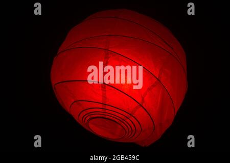 paper chandelier illuminated by a red light on a black background Stock Photo
