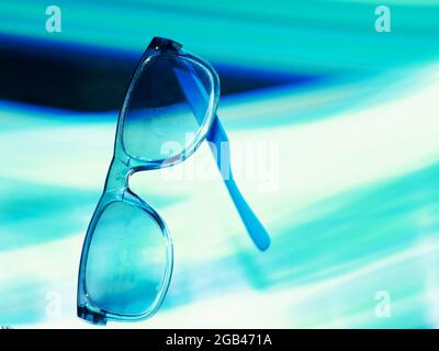 Blueish sunglasses presented on air with light effect shine backdrop, Commercial product presentation image. Stock Photo