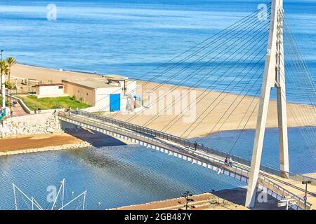 Suspended pedestrian bridge at the mouth of the Fuengirola River, on the Costa del Sol, Andalusia, Spain. Stock Photo