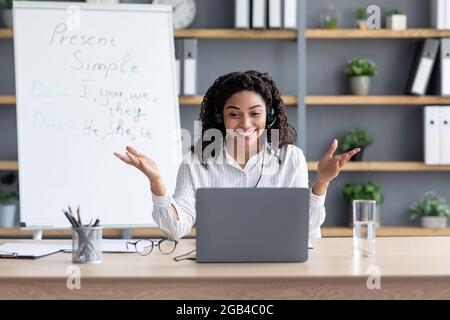Happy african american lady on blackboard background, gesturing Stock Photo