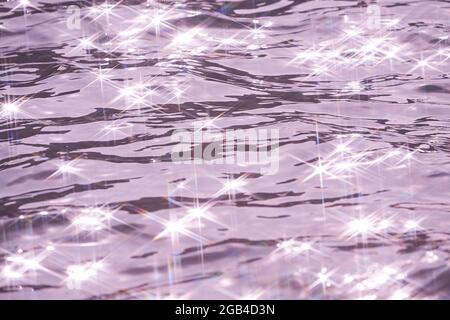Detail of a sunlight reflecting in glittering sea. sparkler in water - background. sea water with sun glare and ripple. Powerful and peaceful nature c Stock Photo