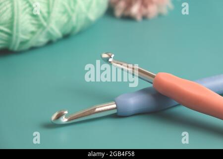 two knitting multicolored crochet hooks on a blue background Stock Photo