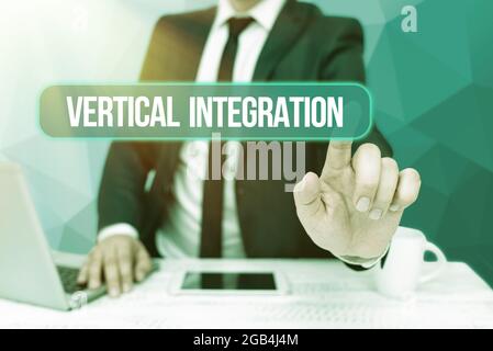 Text showing inspiration Vertical Integration. Concept meaning Merger of companies at different stages of production Bussiness Man Sitting Desk Laptop Stock Photo