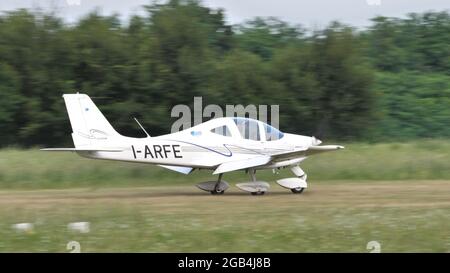 Thiene, Italy JULY, 8, 2021, Ultralight airplane landing on a countryside airstrip in a sunny summer day. Tecnam P2002 JF used as training and private sport airplane. Stock Photo