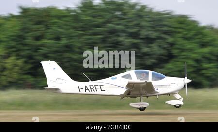 Thiene, Italy JULY, 8, 2021, Ultralight airplane landing on a countryside airstrip in a sunny summer day. Tecnam P2002 JF used as training and private sport airplane. Stock Photo