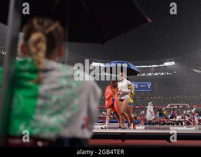 Tokyo, Japan. 2nd August 2021; Olympic Stadium, Tokyo, Japan: Tokyo 2020 Olympic summer games day 10; Womens pole vault qualification, MEIJER Michaela of Sweden shelters under an umbrella with other competitors as rain interupts jumping Credit: Action Plus Sports Images/Alamy Live News Stock Photo