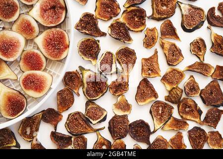 Dried figs lie next to fresh ones on a plate on the table Stock Photo