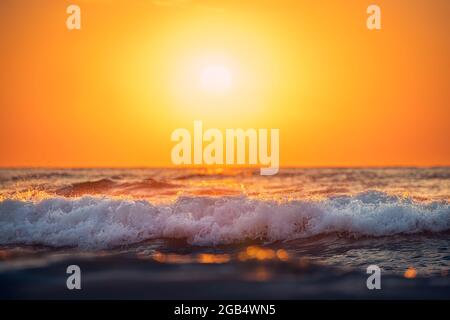 Sea wave close up, low angle view, sunrise over the horizon Stock Photo
