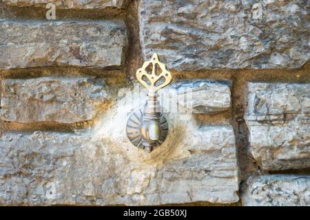 Antique faucet on old stone wall texture abstract background.Historical fountain, antique Turkish faucet on wall Stock Photo