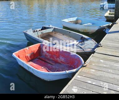 Old work dinghies tied to a dock. Setauket Harbor, New York. Copy space. Stock Photo
