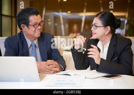 Positive senior entrepreneurs meeting at restaurant table to discuss marketing plan Stock Photo
