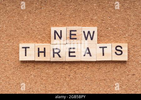 NEW THREATS word written on wood block. NEW THREATS text on wooden table. Business  Covid- 19 Concept Stock Photo