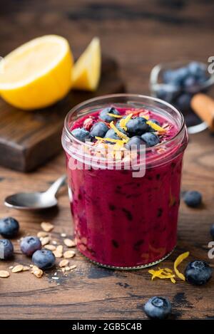 Blueberry smoothie in glass on wooden table. Healthy vegan superfood drink Stock Photo