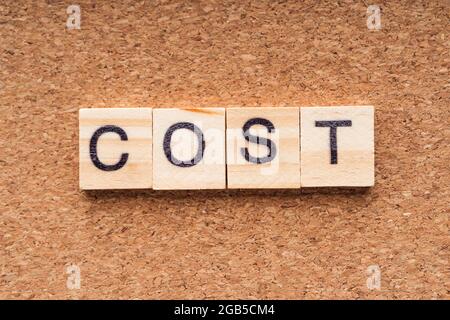 COST word written on wood block. COST text on wooden table. Business Concept Stock Photo