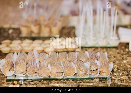Cake bar on wedding. Differnt type of sweeties on the table. Eclair, cake pops, muffins and mamy others desserts Stock Photo