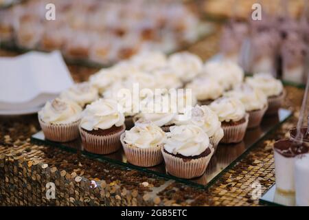 Cake bar on wedding. Differnt type of sweeties on the table. Eclair, cake pops, muffins and mamy others desserts Stock Photo