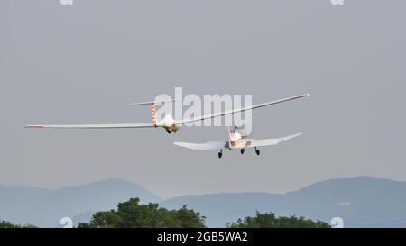 Thiene Italy, JULY, 8, 2021 Propeller private plane tows a modern fiberglass glider in flight. Grob G103 Twin Astir Stock Photo