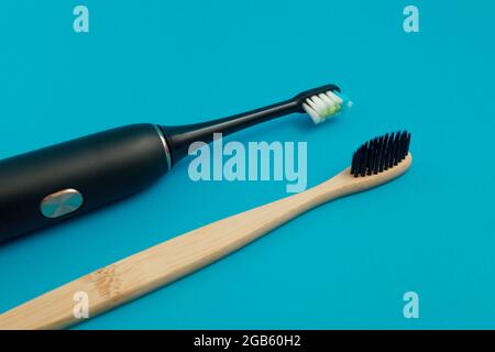 Electric and wooden toothbrush on blue background Stock Photo