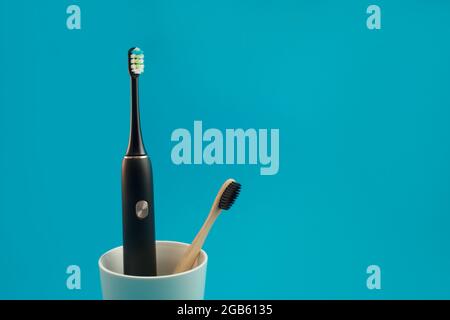 Electric  toothbrush in a glass on a blue background Stock Photo